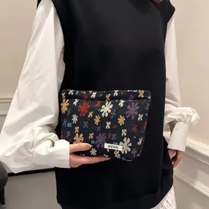 Detailed view of woven cosmetic bag with colorful petal jacquard pattern, compact and portable.