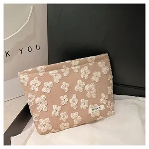 Detailed shot of a stylish khaki cosmetic pouch with white textured floral patterns for daily use.