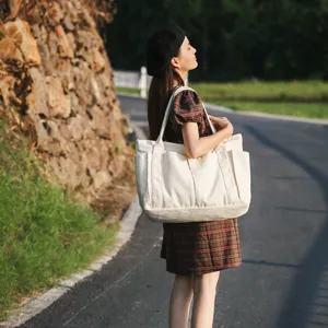Large capacity canvas tote bag for women, casual shoulder bag with multiple exterior pockets.