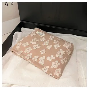 Detailed view of the cosmetic storage pouch with lovely white floral embroidery and soft fabric.