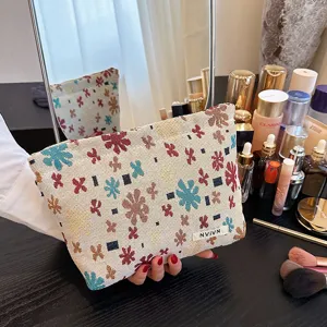 Detailed shot of fabric cosmetic pouch with colorful floral jacquard pattern and woven label.