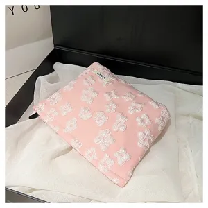 Pink quilted cosmetic pouch with 3D floral pattern, portable makeup storage bag for travel.