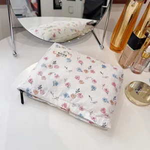 Detailed view of white lace cosmetic bag featuring floral pattern, elegant vintage style pouch.