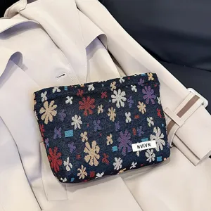 Detail shot of jacquard cosmetic bag featuring floral woven pattern, compact travel pouch.