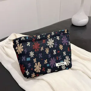 Detailed view of floral jacquard cosmetic pouch, compact fabric makeup bag for travel storage.