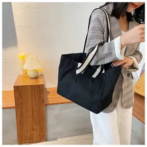 Detailed view of the casual black canvas tote bag, featuring durable straps and large capacity.