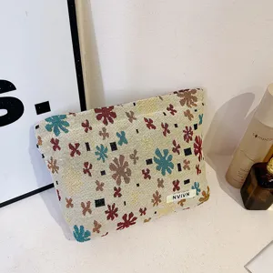 Woven jacquard cosmetic bag linen travel pouch with colorful floral pattern and zipper closure.