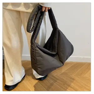 Detail shot of the dark grey puffer tote bag, showcasing the soft padded texture and strap.
