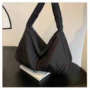 Detailed shot of a black puffer shoulder bag, stylish casual cloud tote bag for women.