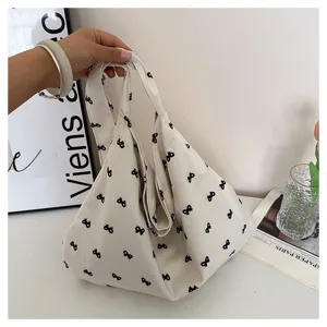 Casual canvas shoulder bag with cute black bow print, minimalist daily tote bag for women.