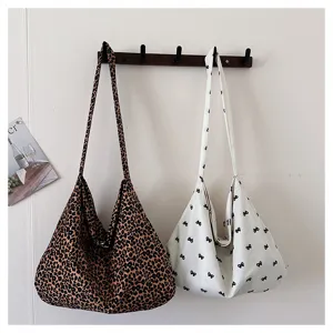 Canvas shoulder tote bag detail, leopard print and bow pattern, casual slouchy style.