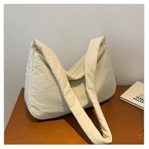Detailed view of the casual white quilted shoulder bag, showing soft padded texture and strap.