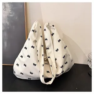 Casual canvas tote bag for women featuring a chic black bow print, large capacity lazy style shoulder bag.
