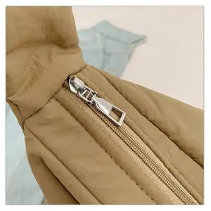 Close-up detail of stylish quilted puffer tote bag, showing soft padded texture and zipper.