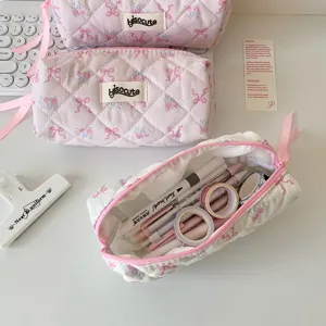 Detailansicht der rosa gesteppten Schleifen-Kosmetiktasche mit Blumenmuster und Stauraum.