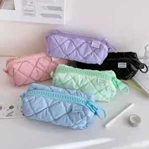 Detailed view of aesthetic quilted pencil cases with large zippers in multiple pastel colors.