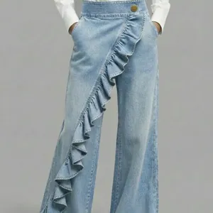 Women's light blue wide leg denim pants with trendy asymmetric ruffle design and high waist.