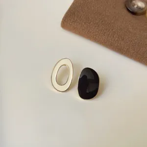 Schicke asymmetrische schwarz-weiße Ohrstecker im französischen Vintage-Stil Detail.