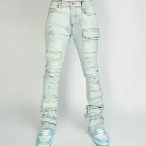 Detailed view of light blue stacked cargo jeans with distressed ripped knees and multiple pockets.