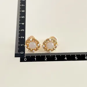 Vergoldete Ohrclips Detailaufnahme mit Messskala, elegantes vintage rundes Design.