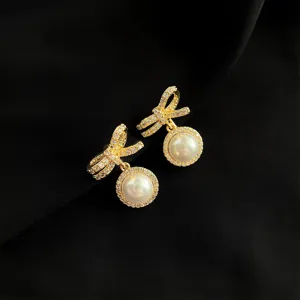 Elegante goldfarbene Schleifen-Clip-Ohrringe mit funkelnden Strasssteinen und Perle.