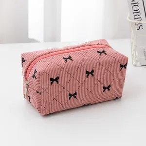 Pink corduroy cosmetic bag with black bow embroidery, cute travel makeup storage pouch for daily use.