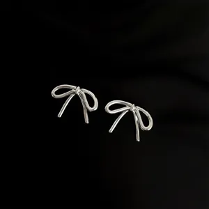 Detailansicht silberner schleifenförmiger Clip-Ohrringe, elegantes Metall-Design ohne Ohrlöcher.