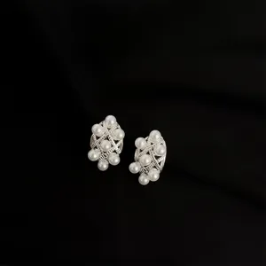 Detailansicht eleganter silberner Perlen-Clip-Ohrringe mit schickem Gitterdesign.
