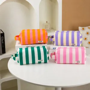 Detailed close-up view of striped plush cosmetic bag, showing soft fabric and portable handle design.