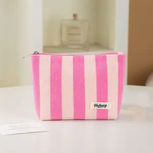 Pink striped cosmetic bag detail view showing soft terry cloth fabric and neat zipper closure for daily use.