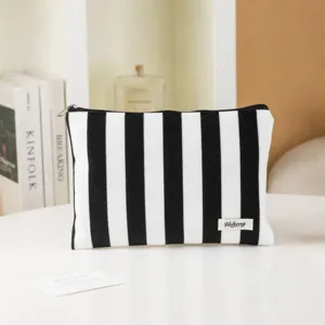 Detailed view of a black and white striped cosmetic bag showcasing clean stitching and durable zipper.