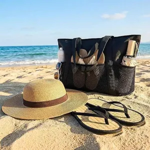 Black mesh beach tote bag detail view with spacious front pocket and durable handles.