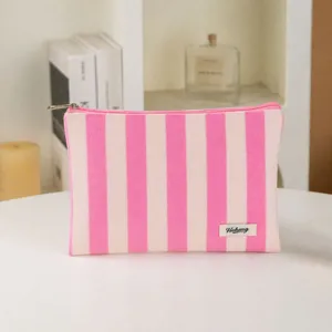 Pink and white striped canvas cosmetic bag, portable makeup pouch with zipper and brand label.