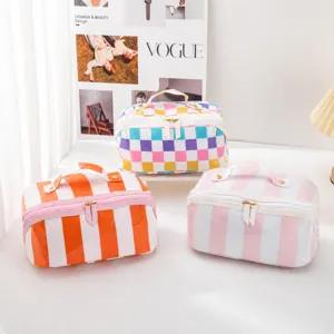 Detailed view of colorful striped and checkerboard PVC cosmetic storage bags, travel essential.