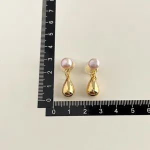 Detailansicht der goldenen Tropfenohrringe mit rosa Perlenakzent und genauer Massangabe.