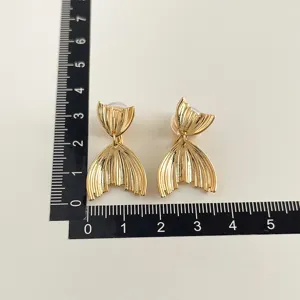 Goldfarbene Ohrclips ohne Ohrloch mit stilvollem Fischschwanz Design Detailansicht.