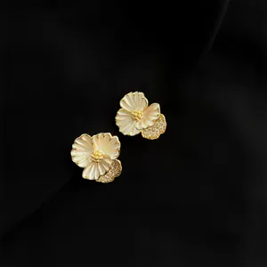 Nahaufnahme eleganter vergoldeter Blumen-Clip-Ohrringe mit weißem Emailleschmuck und Zirkonia.