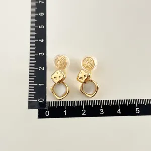 Vergoldete Ohrclips ohne Ohrloch mit Würfel und Perlmutt Anhänger Detailansicht.