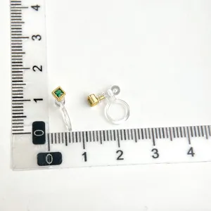 Detailansicht der ohrclips ohne ohrloch mit quadratischem gruenem edelstein und gold.