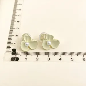 Delicate light yellow flower clip-on earrings with pearl center, elegant size display shot.