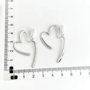 Detailaufnahme silberner asymmetrischer Herz-Ohrclips, stilvolles minimalistisches Design.