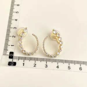 Detailed view of gold-plated crystal clip-on earrings with size measurement rulers.