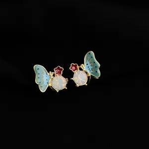 Close-up detail view of butterfly clip-on earrings with blue enamel wings and central crystal.