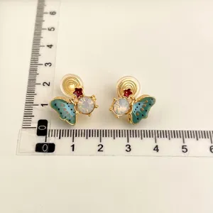 Detailed view of 18K gold plated butterfly clip-on earrings with colorful enamel and crystal accents.