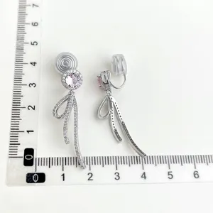 Modische silberne Ohrclips mit zartem rosa Zirkon und funkelndem Schleifenanhänger.