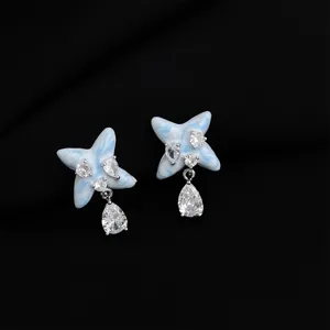 Nahaufnahme Detail der blau emaillierten Stern-Ohrringe mit glitzernden Zirkonia Kristall Anhängern.
