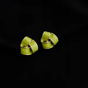 Detailed close-up of chic green enamel geometric clip-on earrings with gold trim for non-pierced ears.