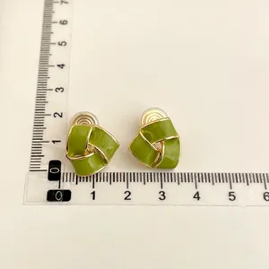 Detailed view of green geometric clip-on earrings with size scale for non-pierced ears.