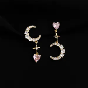Detailed view of asymmetrical moon star pink heart clip-on earrings with sparkly cubic zirconia.