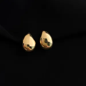 Close-up detail shot of smooth gold teardrop clip-on earrings showcasing polished finish.
